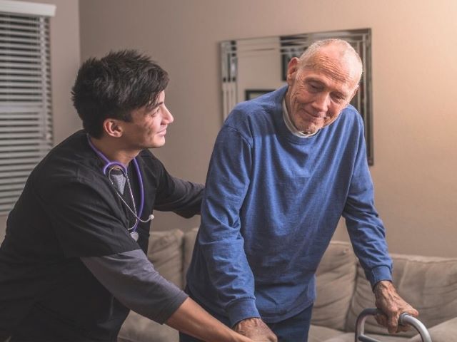 hospice nurse helping patient walk around