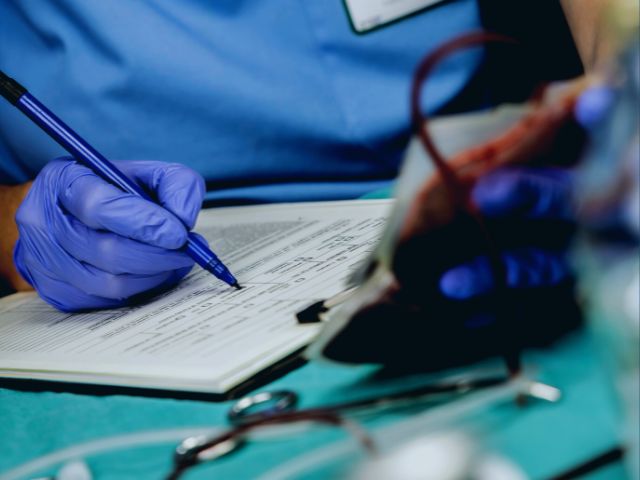 Nurse preparing a blood transfusion for a patient experiencing severe placenta abruptio.