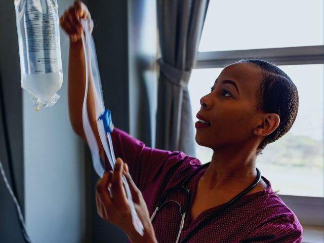 Nurse setting upIV fluids for a patient taking antidiarrheal medication.