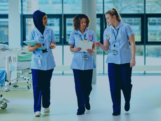 Three baby nurses walking in a line, comparing notes.